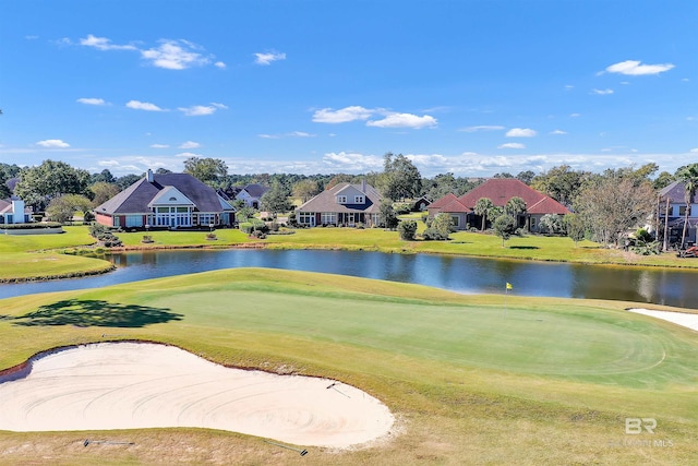 view of home's community featuring a lawn and a water view