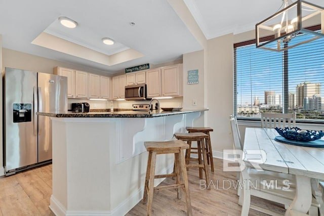 kitchen featuring a chandelier, dark stone countertops, stainless steel appliances, light hardwood / wood-style floors, and decorative light fixtures