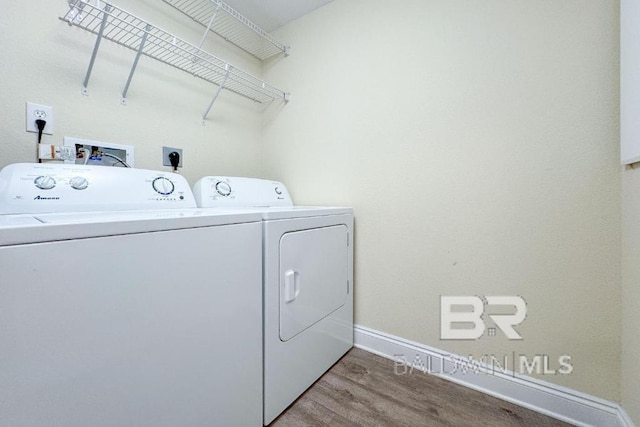 clothes washing area with wood-type flooring and washing machine and dryer