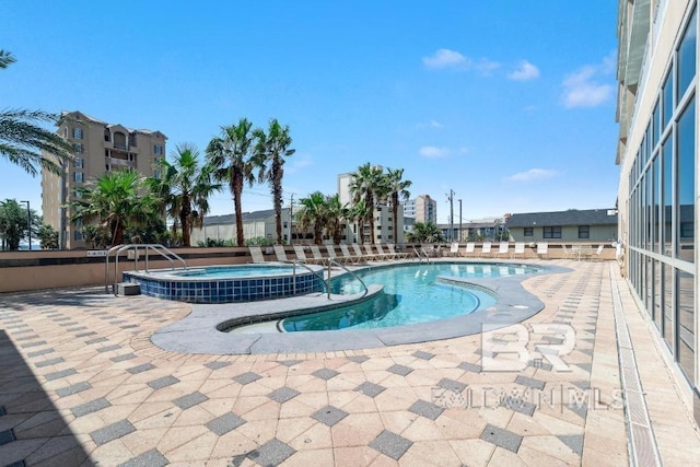 view of swimming pool with a hot tub and a patio area