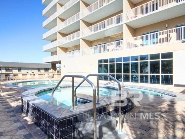 view of swimming pool with a community hot tub