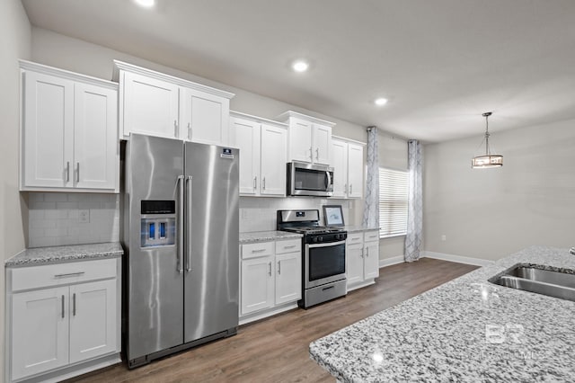 24884 Smarty Jones Cir, Daphne, AL 36526 - kitchen featuring appliances with stainless steel finishes, white cabinets, wood finished floors, tasteful backsplash, and recessed lighting