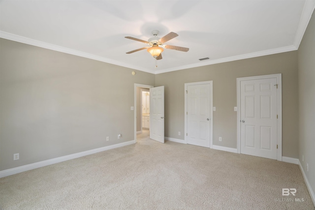 unfurnished bedroom featuring ceiling fan, crown molding, and light carpet