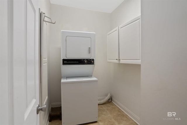 laundry room with cabinets and stacked washing maching and dryer