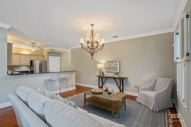 living room featuring ceiling fan with notable chandelier, ornamental molding, and dark wood-type flooring