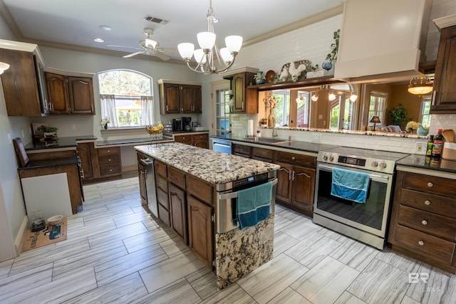 9150 County Road 91, Lillian, AL 36549 - kitchen featuring appliances with stainless steel finishes, a sink, a center island, backsplash, and a chandelier