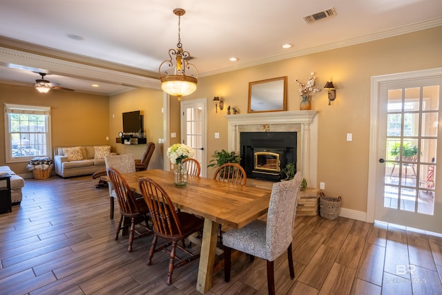 9150 County Road 91, Lillian, AL 36549 - dining space featuring wood finished floors, a glass covered fireplace, ornamental molding, baseboards, and ceiling fan