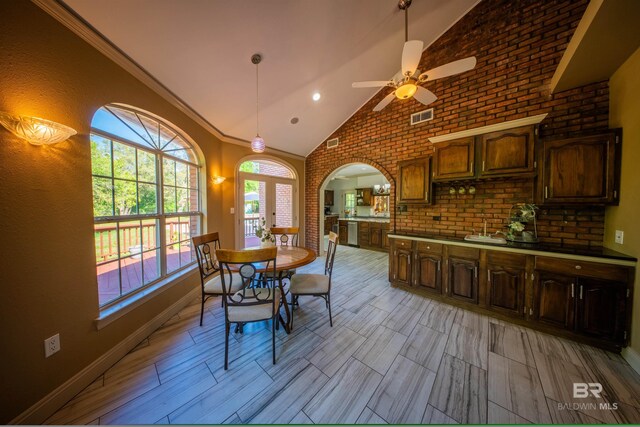 9150 County Road 91, Lillian, AL 36549 - dining area featuring arched walkways, ceiling fan, baseboards, brick wall, and high vaulted ceiling