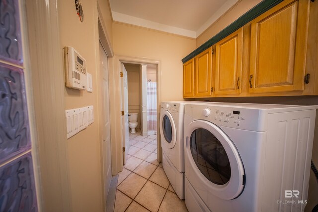 9150 County Road 91, Lillian, AL 36549 - clothes washing area featuring independent washer and dryer, light tile patterned floors, cabinet space, and ornamental molding