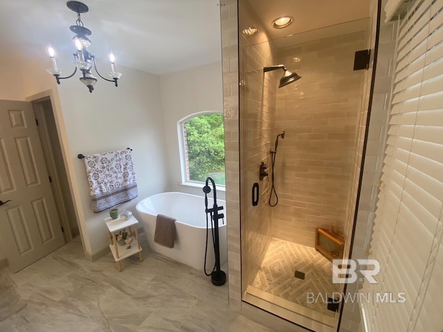 9150 County Road 91, Lillian, AL 36549 - bathroom with a soaking tub, a stall shower, marble look tiles, and a chandelier