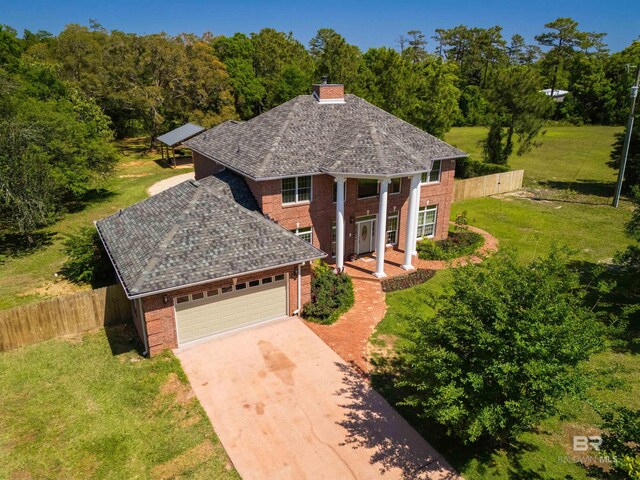 9150 County Road 91, Lillian, AL 36549 - greek revival inspired property featuring brick siding, concrete driveway, a chimney, and a garage