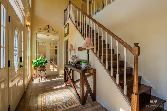 9150 County Road 91, Lillian, AL 36549 - stairway featuring healthy amount of natural light, a high ceiling, baseboards, wood finished floors, and french doors