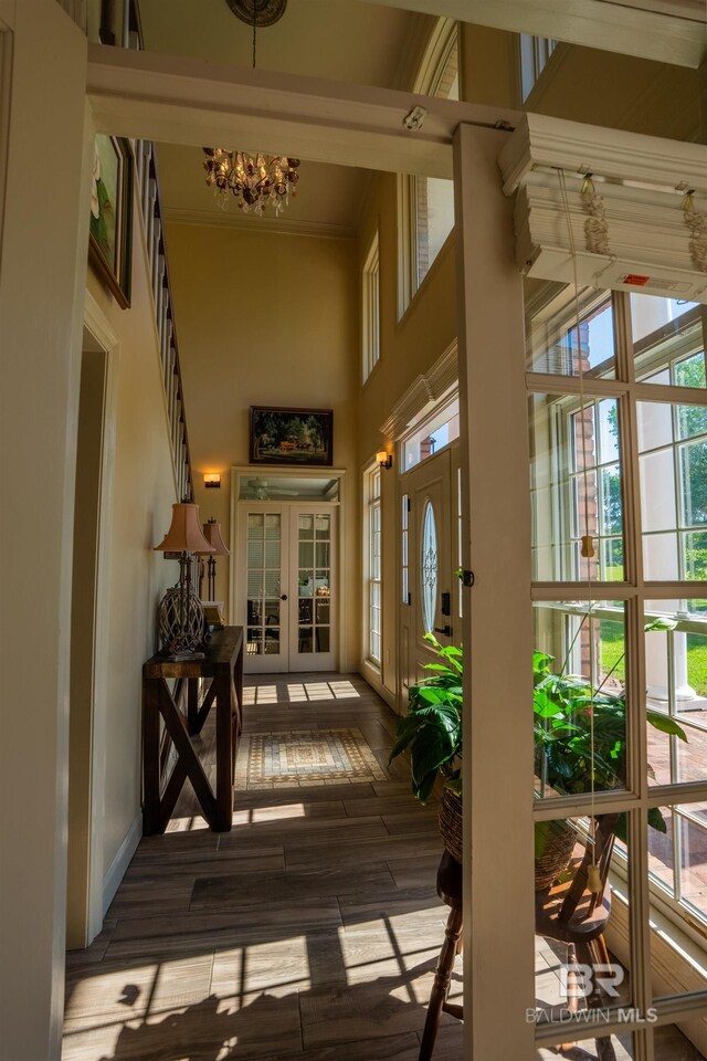 9150 County Road 91, Lillian, AL 36549 - foyer featuring french doors, a towering ceiling, dark wood-style floors, a chandelier, and crown molding