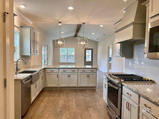 kitchen with an inviting chandelier, light hardwood / wood-style flooring, appliances with stainless steel finishes, premium range hood, and pendant lighting