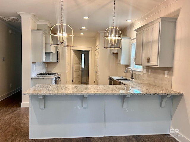 kitchen featuring hanging light fixtures, a breakfast bar area, and gas stove