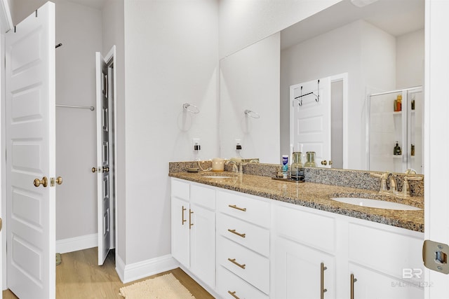 bathroom featuring a shower with shower door, wood-type flooring, and vanity