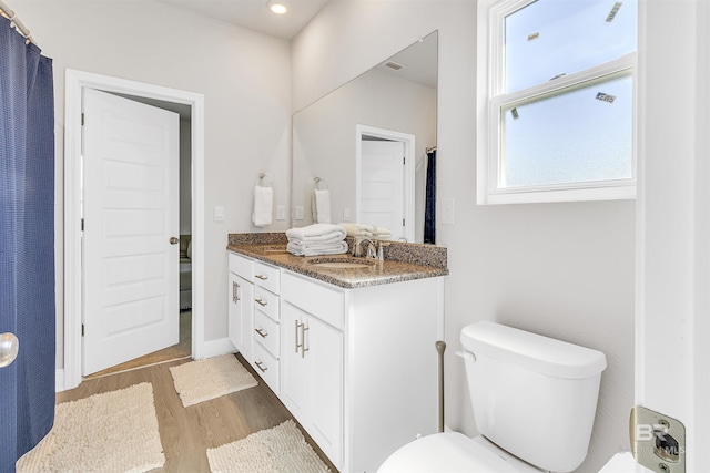 bathroom with toilet, vanity, and hardwood / wood-style flooring