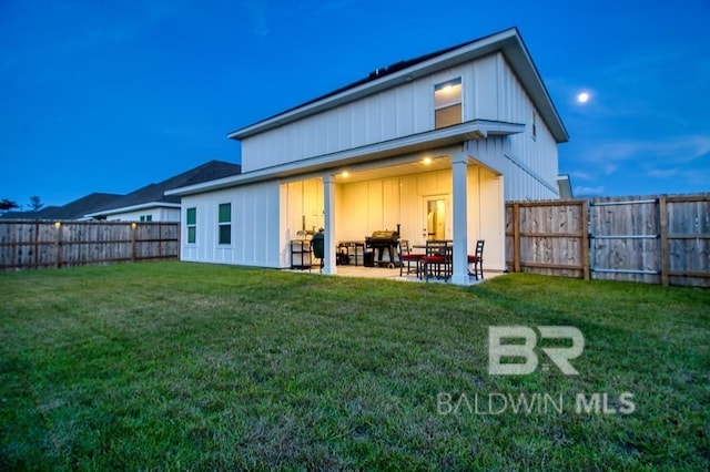 rear view of house with a yard and a patio