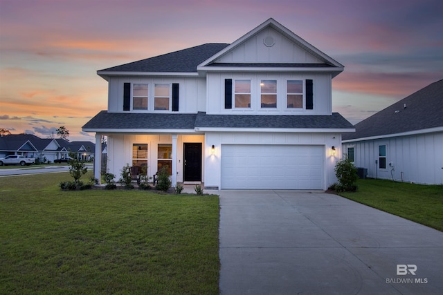 front facade featuring a lawn and a garage