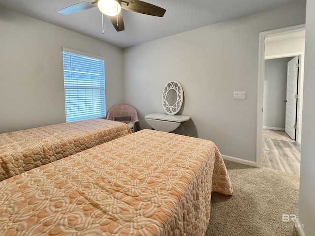 carpeted bedroom with a ceiling fan and baseboards