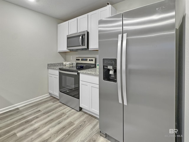 kitchen with light stone countertops, baseboards, white cabinetry, light wood finished floors, and appliances with stainless steel finishes