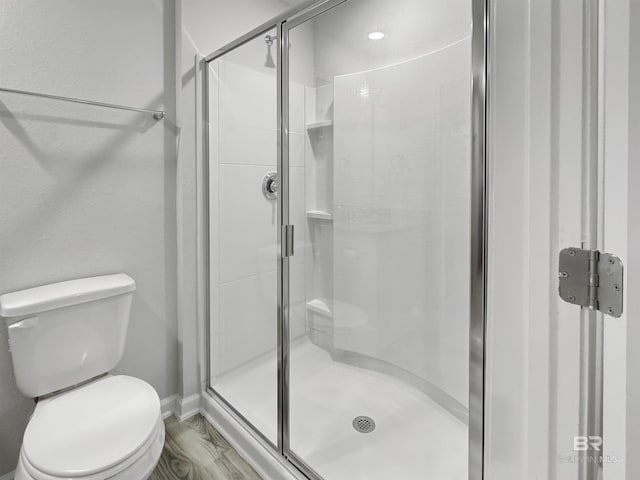 full bathroom with baseboards, toilet, and a shower stall