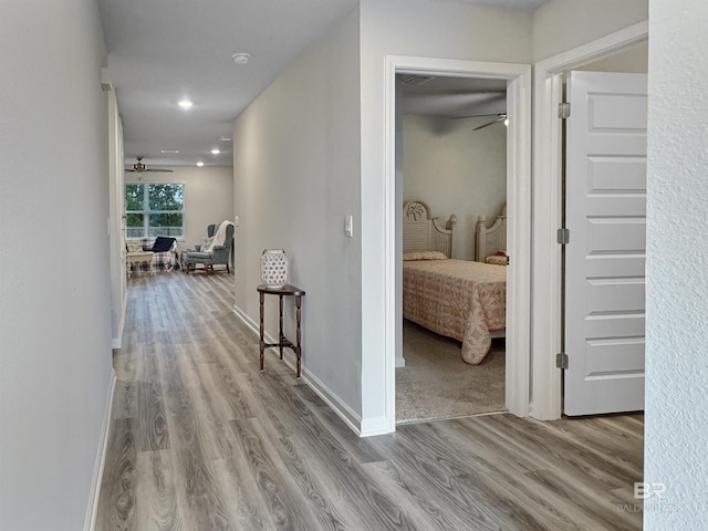 hall with recessed lighting, baseboards, and wood finished floors