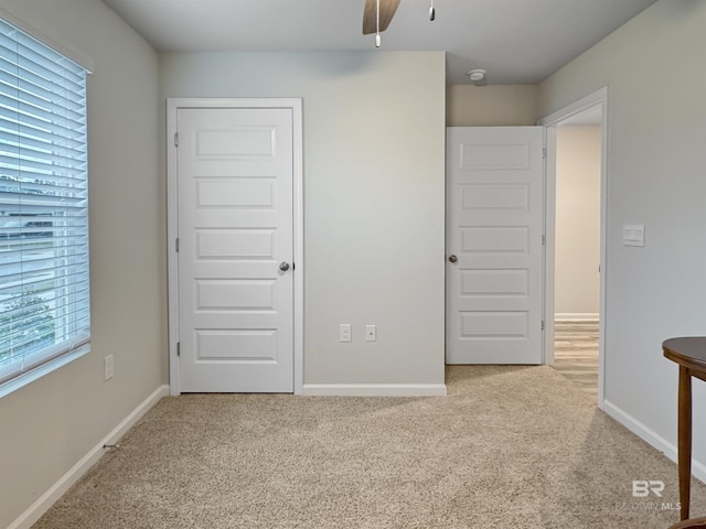 unfurnished bedroom featuring baseboards, a ceiling fan, and carpet