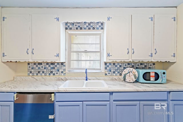 kitchen featuring white cabinetry, stainless steel dishwasher, sink, and backsplash