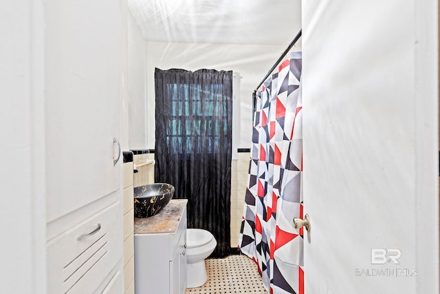 bathroom with tile walls, vanity, toilet, and walk in shower