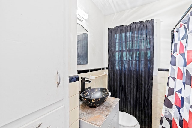 bathroom with vanity, tile walls, curtained shower, and toilet