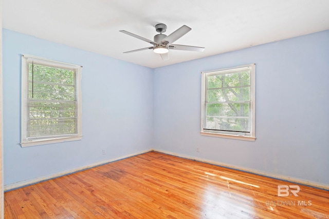 spare room with ceiling fan, light hardwood / wood-style flooring, and a healthy amount of sunlight