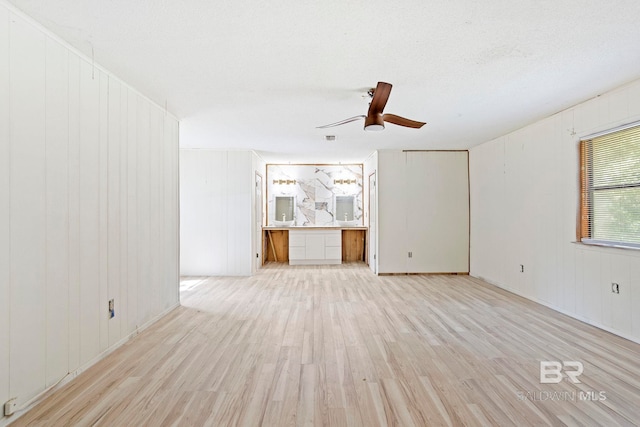 unfurnished room featuring ceiling fan, light hardwood / wood-style flooring, and a textured ceiling