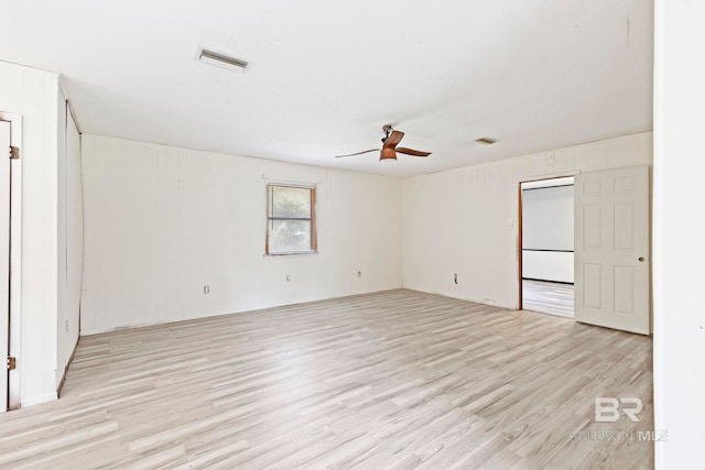 empty room with ceiling fan and light hardwood / wood-style floors