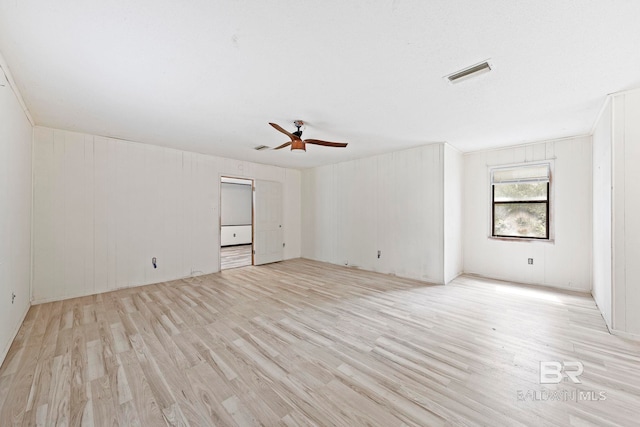 empty room with ceiling fan and light hardwood / wood-style flooring