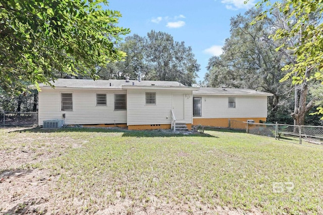 rear view of house featuring central AC and a yard