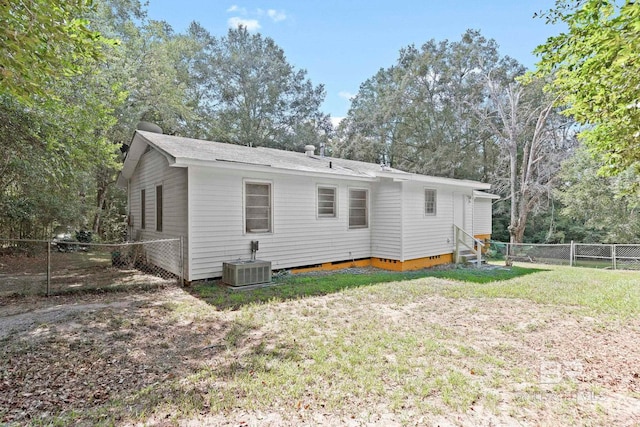 back of property with a lawn and central AC