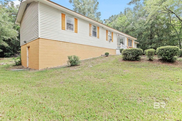 view of side of home with a lawn