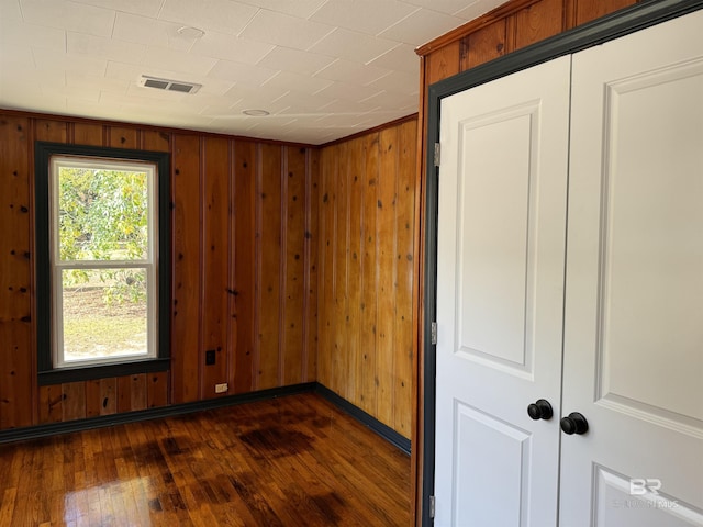 7121 N Century Blvd, Century, FL 32535 - unfurnished room featuring dark wood finished floors, wooden walls, and baseboards