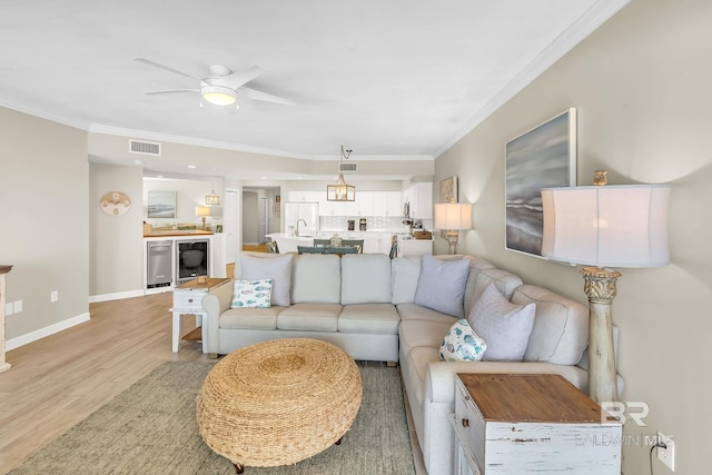 26200 Perdido Beach Blvd Unit 1403, Orange Beach, AL 36561 - living area with light wood-style flooring, ornamental molding, ceiling fan, and beverage cooler