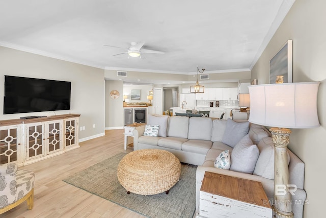 26200 Perdido Beach Blvd Unit 1403, Orange Beach, AL 36561 - living area featuring a ceiling fan, crown molding, and light wood-style flooring