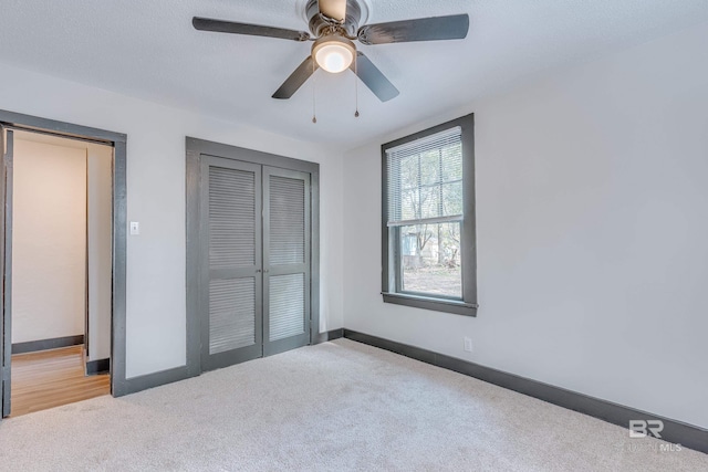 unfurnished bedroom featuring ceiling fan, light colored carpet, and a closet