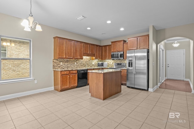 kitchen with a kitchen island, pendant lighting, decorative backsplash, an inviting chandelier, and stainless steel appliances