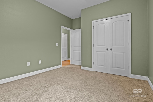 unfurnished bedroom with light colored carpet and a closet