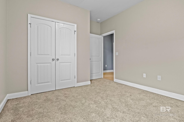 unfurnished bedroom with light carpet and a closet