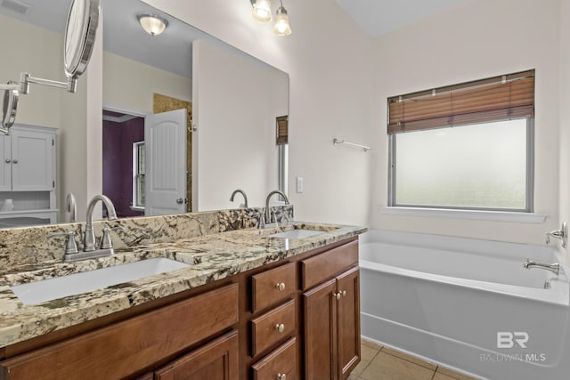 bathroom featuring a bathing tub, tile patterned floors, and vanity