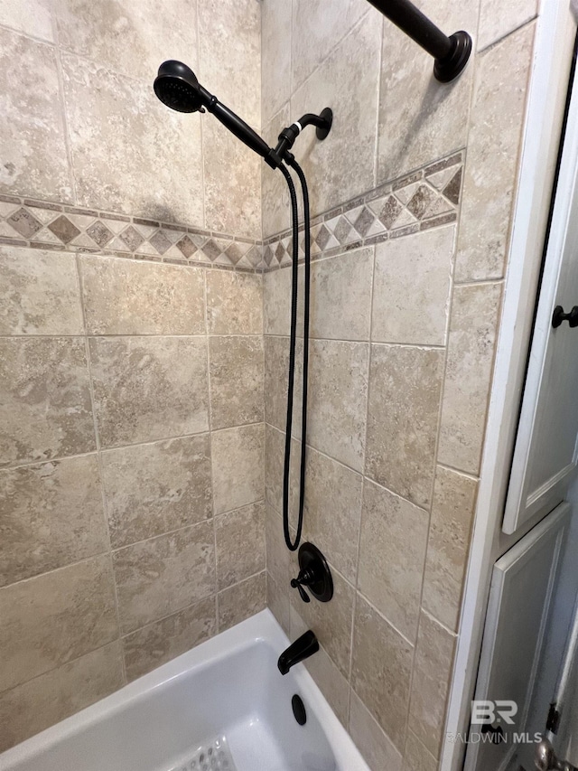 bathroom featuring tiled shower / bath