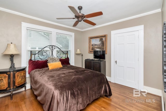 bedroom with ceiling fan, hardwood / wood-style flooring, and ornamental molding