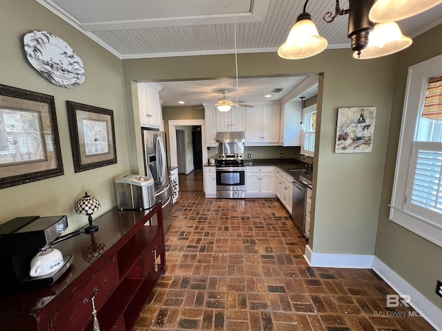 kitchen featuring pendant lighting, stainless steel appliances, crown molding, and white cabinetry