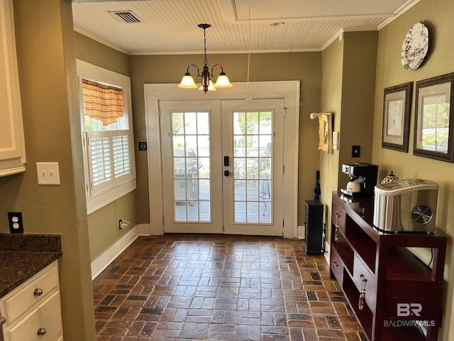 entryway featuring french doors, a wealth of natural light, an inviting chandelier, and ornamental molding